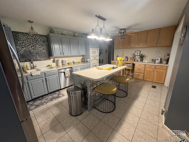 8133 Maple Ln, Newburgh, IN 47630 - kitchen with appliances with stainless steel finishes, a ceiling fan, light tile patterned floors, a sink, and light countertops