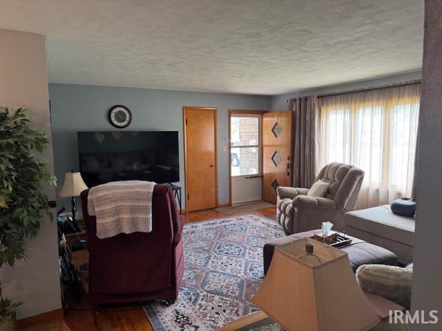 1402 E Culver Rd, Knox, IN 46534 - living room featuring a textured ceiling, wood finished floors, and baseboards