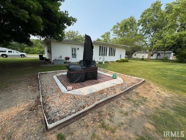 1402 E Culver Rd, Knox, IN 46534 - rear view of property featuring a lawn and central AC