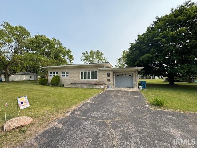 1402 E Culver Rd, Knox, IN 46534 - view of front of house with an attached garage, asphalt driveway, a front yard, and stone siding