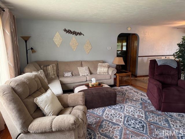 1402 E Culver Rd, Knox, IN 46534 - living area featuring wood finished floors, arched walkways, and a textured ceiling