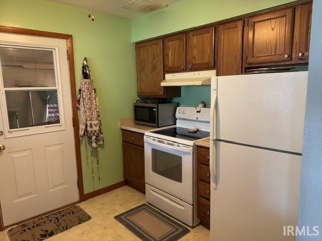 1402 E Culver Rd, Knox, IN 46534 - kitchen featuring white appliances, under cabinet range hood, light floors, and light countertops