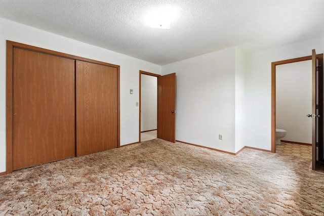 301 W Jefferson St, Columbia City, IN 46725 - unfurnished bedroom with carpet floors, a closet, a textured ceiling, baseboards, and ensuite bath
