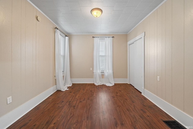 1804 Maple St, Lafayette, IN 47904 - unfurnished bedroom featuring dark wood finished floors, crown molding, baseboards, and wood walls