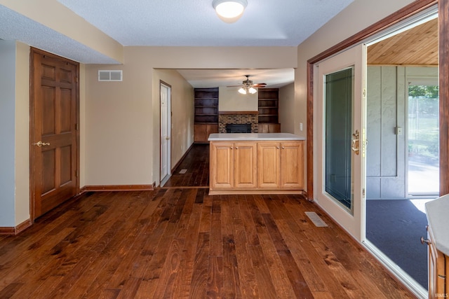 4431 Mccomb Rd, Huntertown, IN 46748 - kitchen featuring a fireplace, ceiling fan, dark wood-style floors, open floor plan, and light countertops