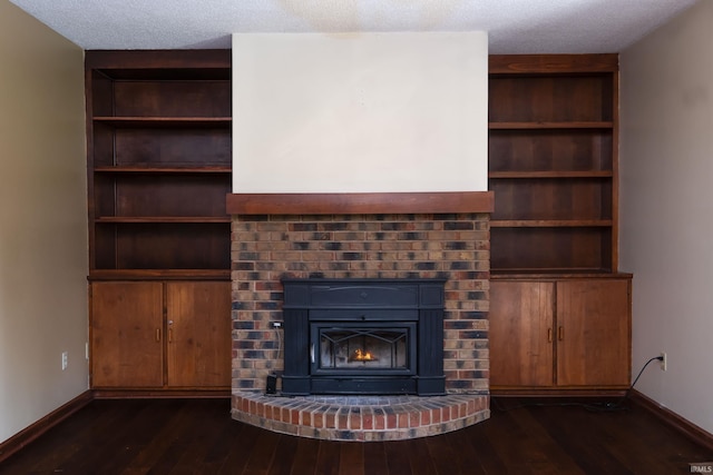 4431 Mccomb Rd, Huntertown, IN 46748 - unfurnished living room with dark wood-style floors, baseboards, a brick fireplace, built in features, and a textured ceiling