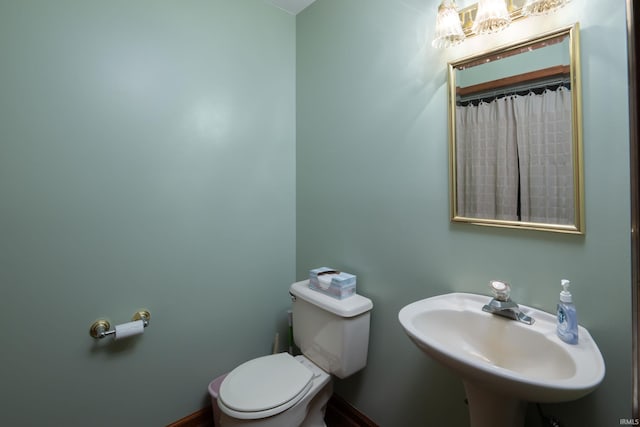 4431 Mccomb Rd, Huntertown, IN 46748 - bathroom featuring toilet, a chandelier, baseboards, and a sink