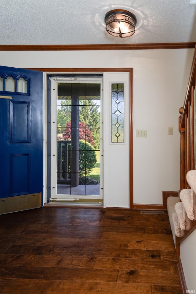 4431 Mccomb Rd, Huntertown, IN 46748 - foyer entrance with a textured ceiling, stairs, dark wood-type flooring, ornamental molding, and baseboards