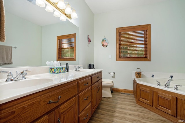 2617 W Union St, Claypool, IN 46510 - bathroom featuring toilet, double vanity, baseboards, a bath, and wood finished floors