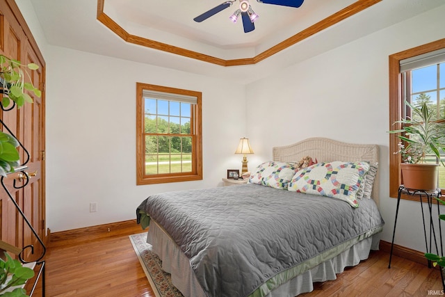 2617 W Union St, Claypool, IN 46510 - bedroom featuring baseboards, light wood-type flooring, a tray ceiling, and ceiling fan