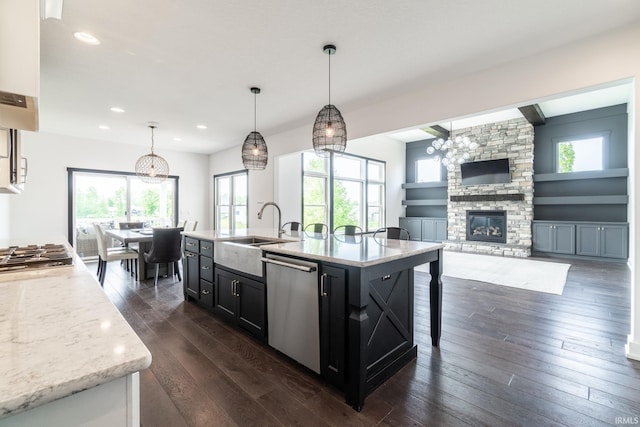 119 Artisan Pass, Fort Wayne, IN 46845 - kitchen with stainless steel appliances, a sink, dark wood finished floors, a fireplace, and an island with sink