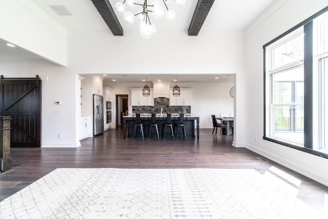 119 Artisan Pass, Fort Wayne, IN 46845 - living room featuring healthy amount of natural light, dark wood-style floors, a chandelier, beam ceiling, and a barn door