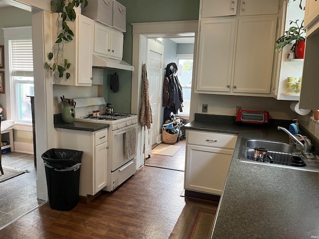 617 S Main St, Goshen, IN 46526 - kitchen featuring white gas stove, a sink, white cabinets, dark wood finished floors, and under cabinet range hood