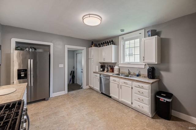 1706 Pierce St, Lafayette, IN 47905 - kitchen with appliances with stainless steel finishes, a sink, white cabinets, light countertops, and baseboards