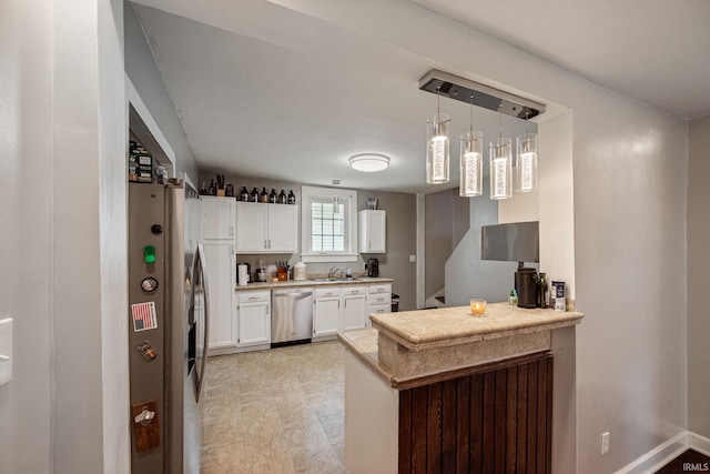 1706 Pierce St, Lafayette, IN 47905 - kitchen with appliances with stainless steel finishes, a peninsula, white cabinets, light countertops, and hanging light fixtures