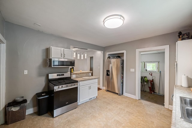 1706 Pierce St, Lafayette, IN 47905 - kitchen with appliances with stainless steel finishes, white cabinetry, light countertops, and baseboards