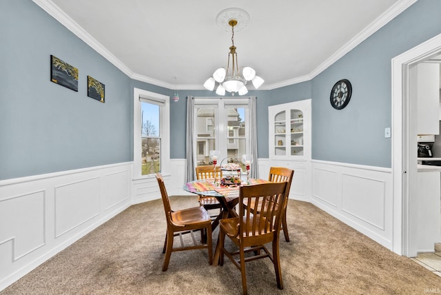 708 E Center St, Warsaw, IN 46580 - dining area with carpet flooring, a chandelier, crown molding, a wainscoted wall, and a decorative wall