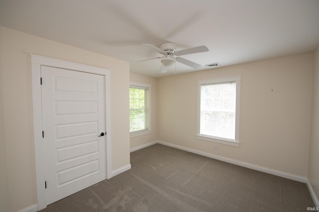 12071 W Tecumseh Bend Rd, Brookston, IN 47923 - empty room with a ceiling fan, baseboards, and dark colored carpet