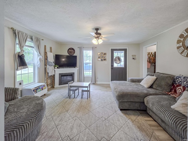 160 SW 5th St, Linton, IN 47441 - living room featuring a textured ceiling, ceiling fan, a glass covered fireplace, ornamental molding, and baseboards
