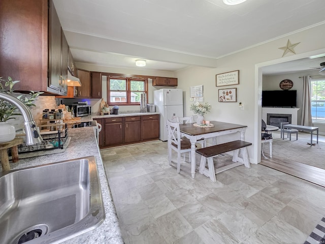160 SW 5th St, Linton, IN 47441 - kitchen with freestanding refrigerator, a sink, light countertops, a glass covered fireplace, and crown molding