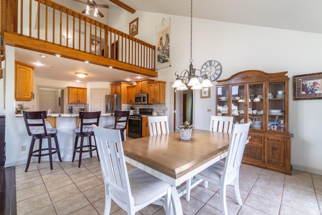 4609 N Sheldon Dr, Churubusco, IN 46723 - dining area featuring a chandelier, light tile patterned floors, a ceiling fan, high vaulted ceiling, and baseboards