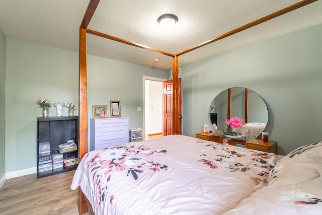 4609 N Sheldon Dr, Churubusco, IN 46723 - bedroom with light wood-style flooring, a textured ceiling, and baseboards
