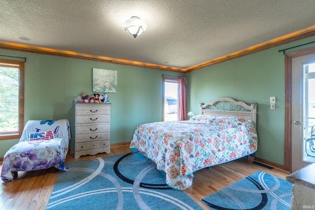 4609 N Sheldon Dr, Churubusco, IN 46723 - bedroom with ornamental molding, a textured ceiling, wood finished floors, and baseboards