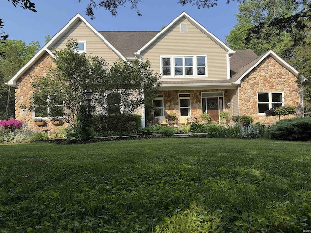 8284 S Mackenzie Ct, Bloomington, IN 47401 - view of front of home featuring stone siding, a front yard, and roof with shingles