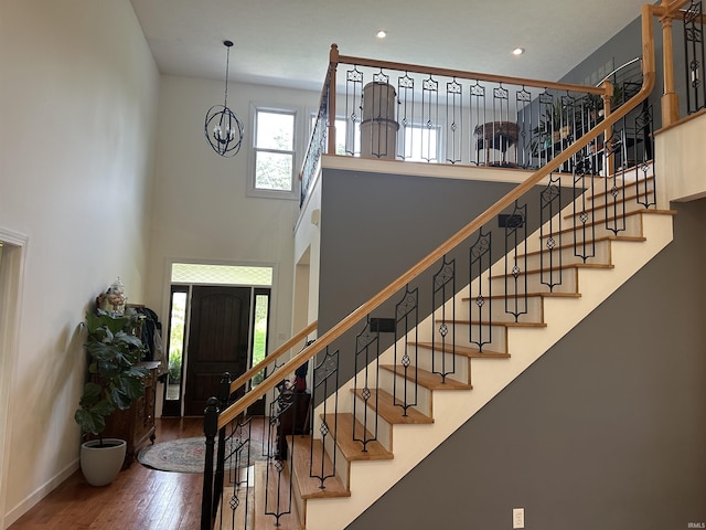 8284 S Mackenzie Ct, Bloomington, IN 47401 - foyer entrance featuring wood finished floors, a towering ceiling, a chandelier, stairs, and recessed lighting