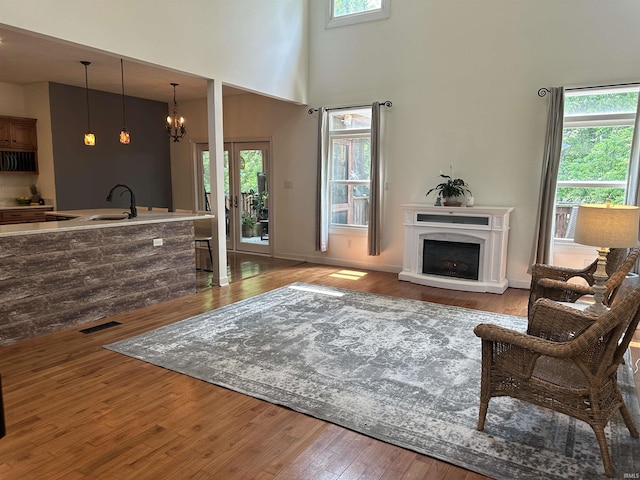 8284 S Mackenzie Ct, Bloomington, IN 47401 - living area featuring a towering ceiling, hardwood / wood-style flooring, a fireplace, and a chandelier