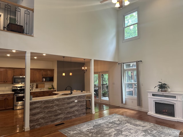8284 S Mackenzie Ct, Bloomington, IN 47401 - kitchen featuring appliances with stainless steel finishes, a high ceiling, dark wood-type flooring, a sink, and a ceiling fan