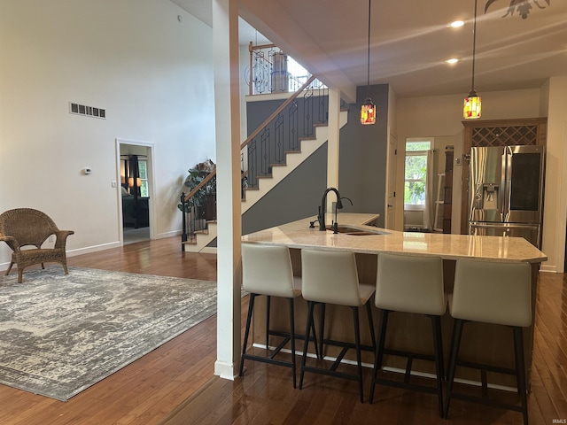 8284 S Mackenzie Ct, Bloomington, IN 47401 - kitchen with stainless steel fridge, a sink, dark wood-style floors, and a breakfast bar area