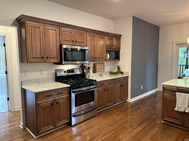 8284 S Mackenzie Ct, Bloomington, IN 47401 - kitchen with appliances with stainless steel finishes, dark wood finished floors, baseboards, and light stone counters