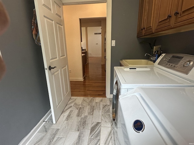 8284 S Mackenzie Ct, Bloomington, IN 47401 - washroom featuring cabinet space, independent washer and dryer, and light wood-type flooring
