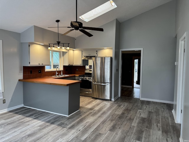 2124 Boulevard St, Rochester, IN 46975 - kitchen with appliances with stainless steel finishes, a sink, a peninsula, high vaulted ceiling, and tasteful backsplash