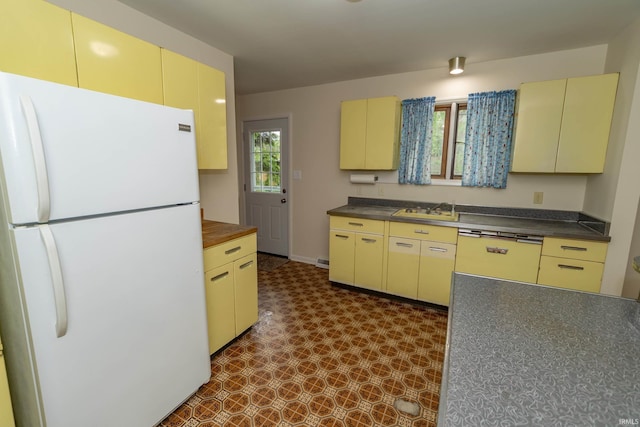 3314 Whitcomb Ave, South Bend, IN 46614 - kitchen featuring freestanding refrigerator, dark floors, cream cabinets, and a sink