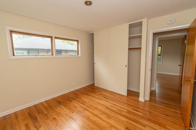 3314 Whitcomb Ave, South Bend, IN 46614 - unfurnished bedroom with light wood-type flooring, baseboards, multiple windows, and a closet