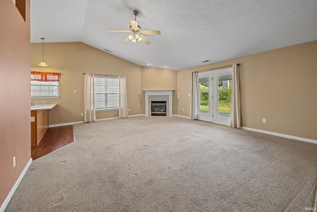 1890 Cal Dr, West Lafayette, IN 47906 - unfurnished living room with healthy amount of natural light, carpet floors, a ceiling fan, baseboards, and lofted ceiling