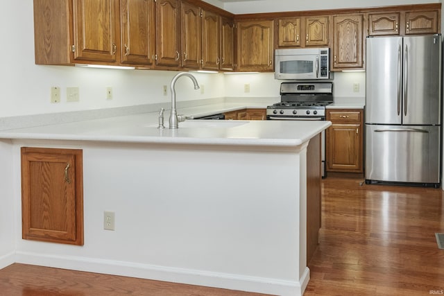 3915 S Allen Ct, Bloomington, IN 47401 - kitchen featuring appliances with stainless steel finishes, a sink, a peninsula, light countertops, and brown cabinets