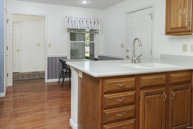 3915 S Allen Ct, Bloomington, IN 47401 - kitchen featuring a sink, light countertops, wood finished floors, brown cabinetry, and a peninsula