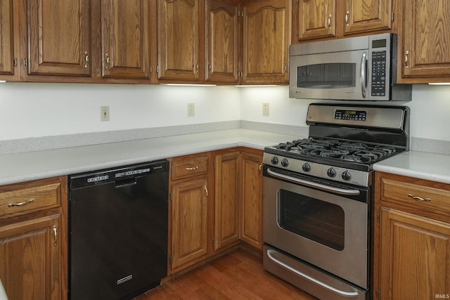 3915 S Allen Ct, Bloomington, IN 47401 - kitchen featuring appliances with stainless steel finishes, light countertops, brown cabinets, and dark wood-style flooring