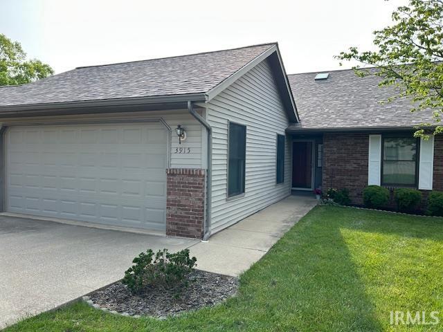 3915 S Allen Ct, Bloomington, IN 47401 - view of side of property featuring brick siding, an attached garage, a shingled roof, concrete driveway, and a lawn