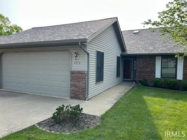 3915 S Allen Ct, Bloomington, IN 47401 - view of side of property with brick siding, an attached garage, a shingled roof, concrete driveway, and a lawn