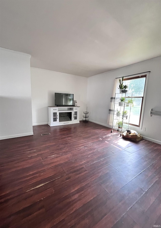 1818 N Indiana Ave, Kokomo, IN 46901 - unfurnished living room featuring baseboards, wood finished floors, and a glass covered fireplace