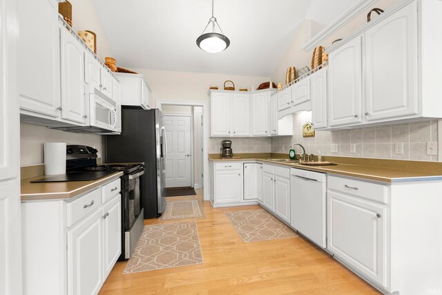 2410 Deerfield Ct, Decatur, IN 46733 - kitchen featuring white appliances, white cabinets, light wood finished floors, a sink, and vaulted ceiling