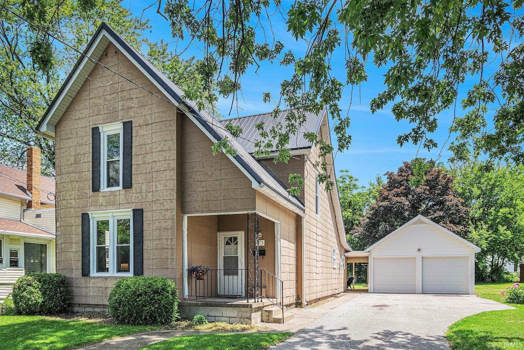773 N E St, Wabash, IN 46992 - view of front facade featuring an outbuilding, a detached garage, and a front lawn