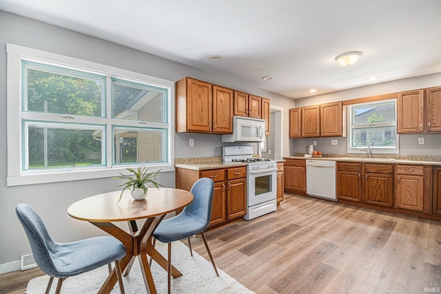 773 N E St, Wabash, IN 46992 - kitchen featuring white appliances, a sink, light wood-style floors, brown cabinets, and light countertops