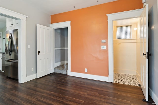 819 S 8th St, Goshen, IN 46526 - unfurnished bedroom with stainless steel fridge with ice dispenser, dark wood-style floors, and baseboards