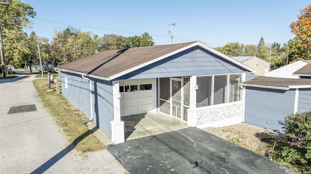 104 N Jefferson St, Pine Village, IN 47975 - single story home with a sunroom, driveway, a shingled roof, and a garage