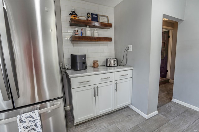 104 N Jefferson St, Pine Village, IN 47975 - kitchen with freestanding refrigerator, baseboards, decorative backsplash, wood tiled floors, and white cabinetry